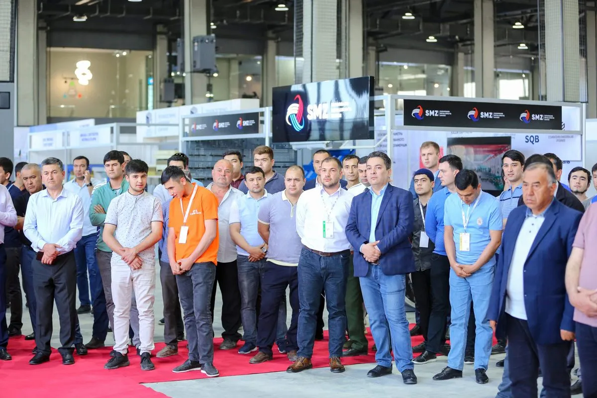 Participants wearing badges in front of a stand with brand logos